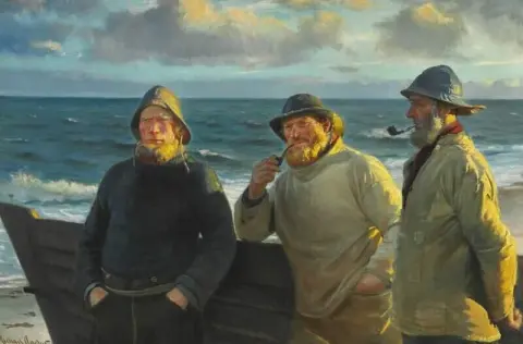 Fishermen From Skagen Standing On The Beach In The Evening Sun