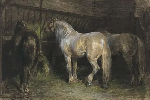 Hester som spiser høy i en stall