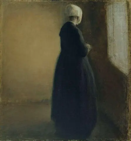 Una vecchia donna in piedi accanto a una finestra 1885